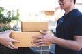 Delivery mail man giving parcel box to recipient, Young owner accepting of cardboard boxes package from post shipment, Home Royalty Free Stock Photo