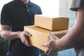 Delivery mail man giving parcel box to recipient, Young owner accepting of cardboard boxes package from post shipment, Home Royalty Free Stock Photo