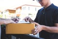 Delivery mail man giving parcel box to recipient, Young man signing receipt of delivery package from post shipment courier at home Royalty Free Stock Photo