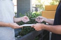 Delivery mail man giving parcel box to recipient, Young man signing receipt of delivery package from post shipment courier at home