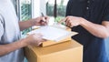 Delivery mail man giving parcel box to recipient, Young man signing receipt of delivery package from post shipment courier at home