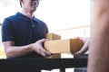 Delivery mail man giving parcel box to recipient, Young owner accepting of cardboard boxes package from post shipment, Home Royalty Free Stock Photo