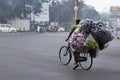 Delivery man on a bicycle overloaded with packets waitng at the stoplight near a square in Pune Royalty Free Stock Photo
