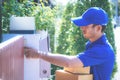 Delivery man in Blue handing packages to home Royalty Free Stock Photo