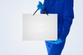Delivery man in a blue jumpsuit and medic`s nitrille gloves holding a shopping bag Royalty Free Stock Photo