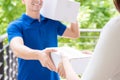 Delivery man in blue uniform delivering parcel box to a woman