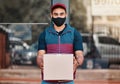 Delivery man, box and covid face mask working for courier service with package, shipment or parcel outdoor. Express Royalty Free Stock Photo