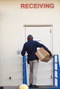 Delivery man with box deliver cargo to receiveng door Royalty Free Stock Photo