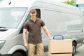 Delivery Man With Cardboard Boxes On Trolley Royalty Free Stock Photo