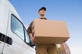 Delivery Man Carrying Cardboard Box By Truck Against Sky Royalty Free Stock Photo