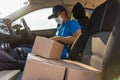 Delivery man courier online with boxes with uniform sitting in driving car Royalty Free Stock Photo