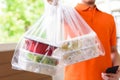 Delivery man delivering Asian food in take away boxes to customer at home Royalty Free Stock Photo