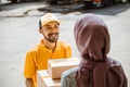 Delivery man delivering boxes to female customers wearing headscarves