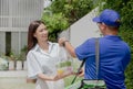 Delivery man delivering food to a beautiful Asian girl in front of the house