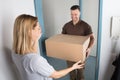 Delivery Man Giving Parcel Box To Young Woman Royalty Free Stock Photo