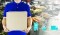 Delivery man hand holding paper box package in blue uniform and icon media symbol on grocery background. Delivery service Royalty Free Stock Photo