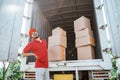 Delivery man having back pain while working with cardboard boxes Royalty Free Stock Photo