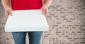 Delivery man holding box against concrete wall Royalty Free Stock Photo