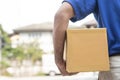 A delivery man holding boxes of paper containers.