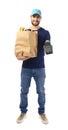 Delivery man holding paper bag with food and payment terminal on white background Royalty Free Stock Photo