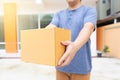 Delivery man holding pile of cardboard boxes in front delivering package to customer, close up at hand and box Royalty Free Stock Photo