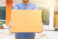 Delivery man holding pile of cardboard boxes in front delivering package to customer, close up at hand and box Royalty Free Stock Photo