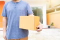Delivery man holding pile of cardboard boxes in front delivering package to customer, close up at hand and box Royalty Free Stock Photo