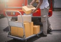 Delivery Man Lifting Package Boxes on The Cart. Worker Courier. Delivery Trucks. Delivering Shipment to Customers Royalty Free Stock Photo