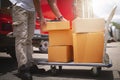 Delivery Man Lifting Package Boxes on The Cart. Worker Courier. Delivery Trucks. Delivering Shipment to Customers. Royalty Free Stock Photo