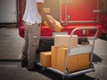 Delivery Man Lifting Package Boxes on The Cart. Worker Courier. Delivery Trucks. Delivering Shipment to Customers. Royalty Free Stock Photo