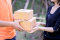 Delivery man in orange handing packages to a woman