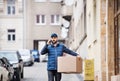 Delivery man with a parcel box on the street. Royalty Free Stock Photo