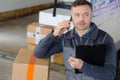 Delivery man phoning before leaving warehouse Royalty Free Stock Photo