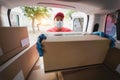 Delivery man picking up box from van while wearing face mask - Focus on face Royalty Free Stock Photo