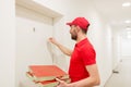 Delivery man with pizza boxes knocking on door Royalty Free Stock Photo