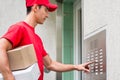 Delivery man pressing button of intercom Royalty Free Stock Photo