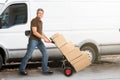 Delivery Man Pushing Parcels On Handtruck