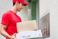 Delivery man carrying mail packages using the intercom