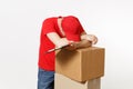 Delivery man in red uniform isolated on white background. Male courier in cap, t-shirt holding pen, clipboard with Royalty Free Stock Photo