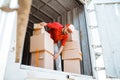delivery man in red unloads several boxes from a container Royalty Free Stock Photo