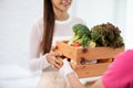 Delivery man sending wooden box of fresh organic