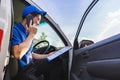 Delivery man sitting on van seat and calling to customer. Royalty Free Stock Photo