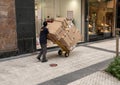 Delivery man in street with lots of boxes on a hand trolley.