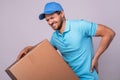 Delivery man suffering from a back pain while carrying heavy box Royalty Free Stock Photo