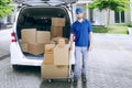 Delivery man with trolley and car Royalty Free Stock Photo