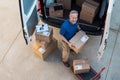 Delivery man unloading parcel Royalty Free Stock Photo