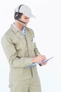 Delivery man using headphones while writing on clipboard Royalty Free Stock Photo