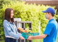 Delivery man wear face mask grocery fast service giving fresh food vegetable to woman customer Royalty Free Stock Photo