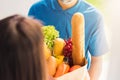 Delivery man wear protective face mask making grocery giving fresh food to woman customer Royalty Free Stock Photo