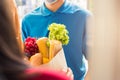 Delivery man wear protective face mask making grocery giving fresh food to woman customer Royalty Free Stock Photo